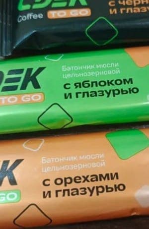 The image shows three energy drink bars stacked on top of each other. The top bar is black and has the text "Coffee" and "To go" printed on it. The middle bar is green and has the text "�� ��ро��о��им ��енед��еро��" and "�� ��ро��о��им ��а ��раво��о��ино��" printed on it. The bottom bar is orange and has the text "�� �