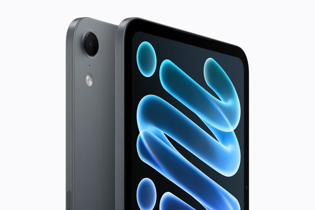 The image shows a dark gray iPhone, possibly an iPhone 6 or iPhone 6s, with a black camera lens on the back. The phone is angled slightly to the right, revealing its sleek design and vibrant blue and cyan gradient screen. The screen features a stylized, abstract design with curved lines and circles. The phone is set ag