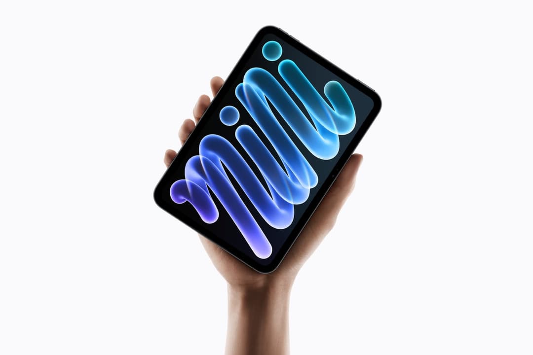 The image shows a hand holding a black iPhone in a way that suggests it is being held up against a white background. The phone's screen displays the word "Minion" in a stylized, flowing font with a gradient of blue and purple colors. The hand and phone are centrally positioned in the frame, with the phone angled slight