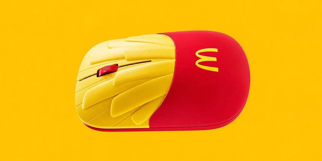 A yellow-and-red computer mouse shaped like a McDonald's fries carton, shown in side view on a yellow background. The golden arches logo is visible on the red side.