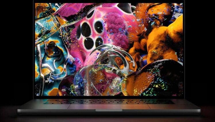 A laptop with its lid open shows a colorful abstract 3D render on a black background, with glossy pink, orange, and teal forms covered in droplets. The screen is glowing against a dark setting, with no visible text or brand.