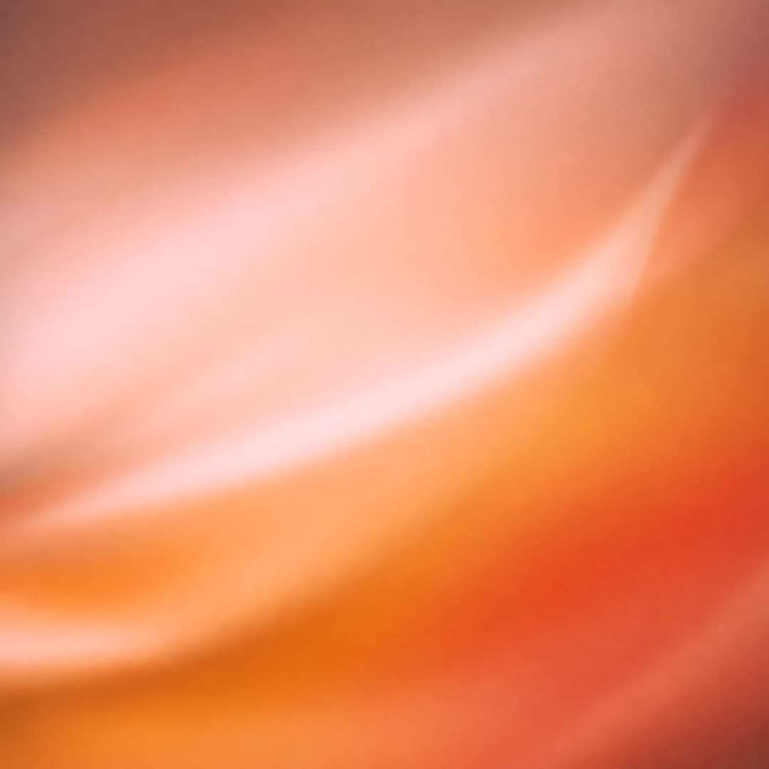 The image presents an abstract composition dominated by a gradient of orange and pink hues. The colors blend seamlessly, creating a sense of fluidity and movement. The colors are predominantly orange and pink, with the pink transitioning into a lighter shade towards the center. The image is devoid of any discernible ob