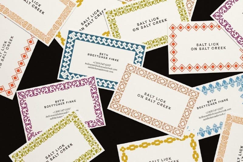 The image shows a collection of business cards scattered across a black background. Each card features a unique design and text, with a variety of colors and patterns. The text on the cards includes "Salt Lick on Salt Creek" and "Salt Lick on Salt Creek", along with the names "Beth Boettcher Finke" and "Beth Boettcher