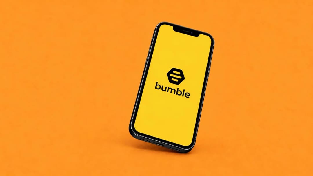 The image shows a black iPhone with a glossy finish, positioned at an angle on a vibrant orange background. The phone's screen is illuminated, displaying the logo of the company "bumble" in bold black letters. The logo consists of a stylized honeycomb design. The phone appears to be a newer model, possibly an iPhone X,