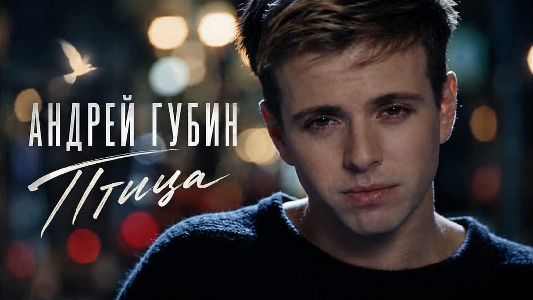 The image shows a young man with short, light brown hair, wearing a dark blue sweater, looking off to the side with a serious expression. The background is out of focus, with blurred lights that could be city lights, creating a bokeh effect. The text "���������������� ��������" is written in white cursive font above th