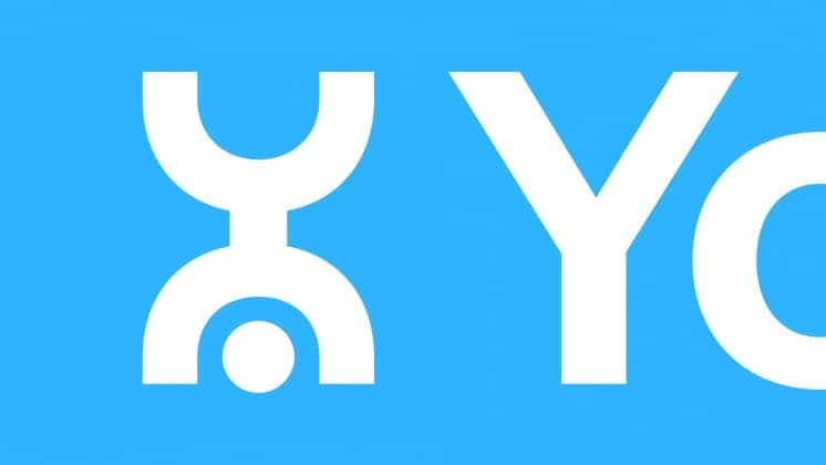 The image presents a striking contrast of white and blue against a solid blue background. Dominating the right side of the image is a large, bold, white "Y" with a smaller white "O" incorporated into its design. The "Y" is positioned slightly above the "O", creating a dynamic visual effect. The white elements are the o