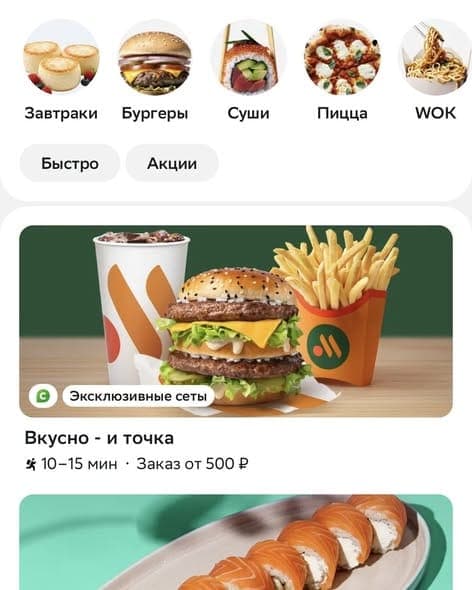 A food delivery app screen showing circular category icons (Завтраки, Бургеры, Суши, Пицца, WOK) and filter chips (Быстро, Акции), with a promo card for "Вкусно — и точка" showing a burger, fries and drink, delivery time 10–15 min, and minimum order from 500 ₽.