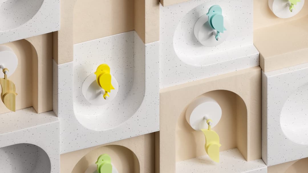 The image presents a 3D rendering of a wall composed of white and beige blocks, each featuring a unique bird-shaped object. The birds are depicted in various colors, including yellow, blue, and green, and are attached to the blocks using white hooks. The blocks are arranged in a grid-like pattern, creating a sense of d