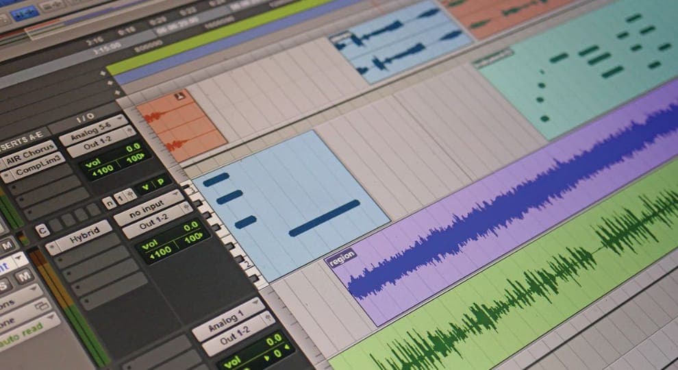 The image shows a close-up view of a computer screen displaying a music production software interface. The interface is primarily gray and white, with a variety of colored elements and text. The software includes a timeline with a series of audio clips, a waveform editor, and a control panel with various parameters and