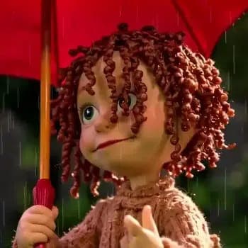 The image shows a doll with curly red hair, wearing a brown sweater, holding a red umbrella. The doll's face is slightly tilted to the left, and it has a neutral or slightly sad expression. The background is blurred, suggesting an outdoor setting, possibly a garden or park, with a soft, diffused light. The doll's hands