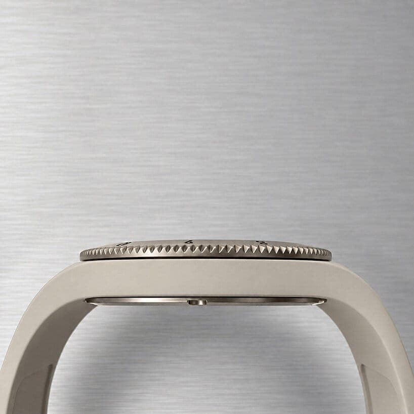 A side-profile view of a grey titanium-bezel watch with a rubber strap on brushed steel shows the knurled bezel and the case edge. No legible brand text is visible.