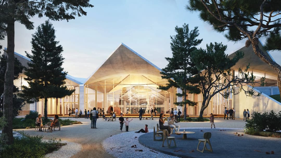 The image depicts a modern architectural structure with a unique triangular roof design, constructed from light-colored wood. The building features a large glass entrance, allowing natural light to illuminate the interior. The building is surrounded by a lush garden with trees and shrubs, creating a serene atmosphere.