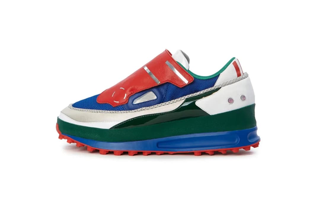 The image shows a single, vibrant sneaker with a striking design. The sneaker is predominantly blue, with a red section on the side and a white section on the back. The blue section features a textured pattern, while the red section has a more solid appearance. The sneaker has a white section on the back, which is ador