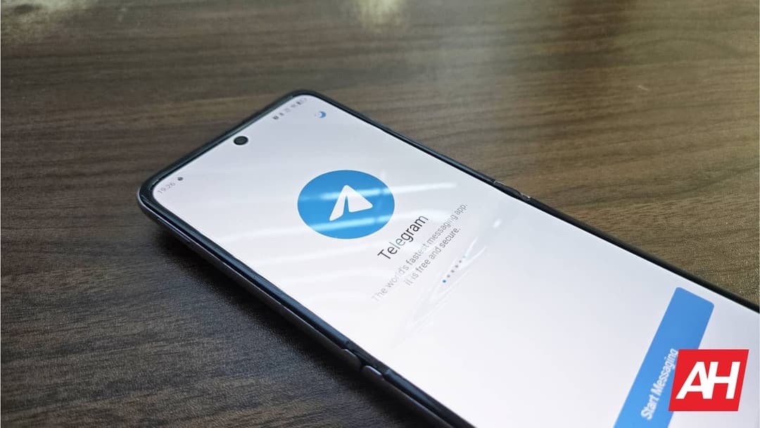 The image shows a black smartphone lying on a wooden surface. The phone's screen is illuminated, displaying the Instagram app. The Instagram app icon, a blue circle with a white arrow, is prominently featured on the screen. The screen also displays the text "Telegram is the fastest messaging app. It is free and secure.