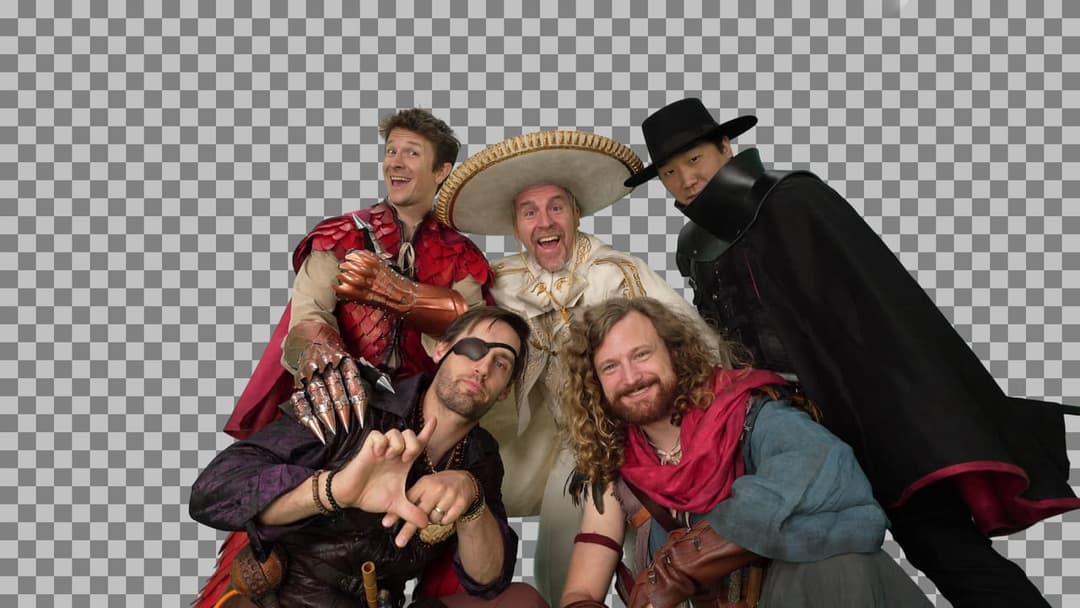 The image shows five men dressed in costumes, possibly for a theatrical performance or a themed event. The man on the far left is wearing a red and gold outfit with a cape, and the man next to him is wearing a white outfit with a sombrero. The third man is wearing a black outfit with a cape, and the fourth man is weari