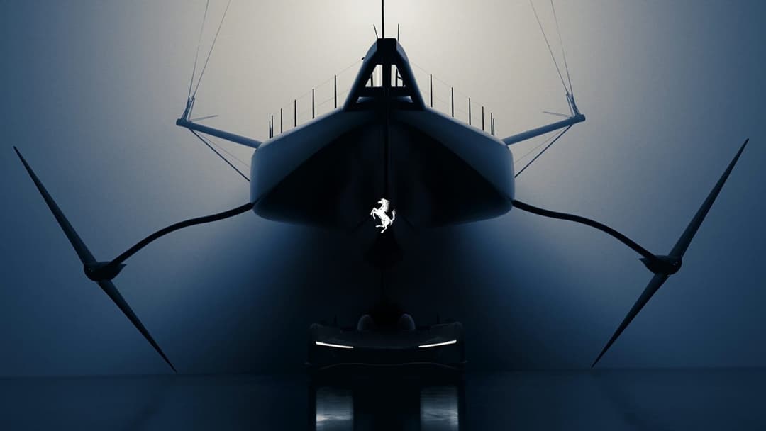 The image depicts a futuristic yacht, possibly a concept car, suspended in a dimly lit room. The yacht has a sleek, streamlined design with a pointed bow and two large, pointed wings extending from the sides. The hull is primarily dark gray or black, and the yacht is illuminated from the front, creating a stark contras