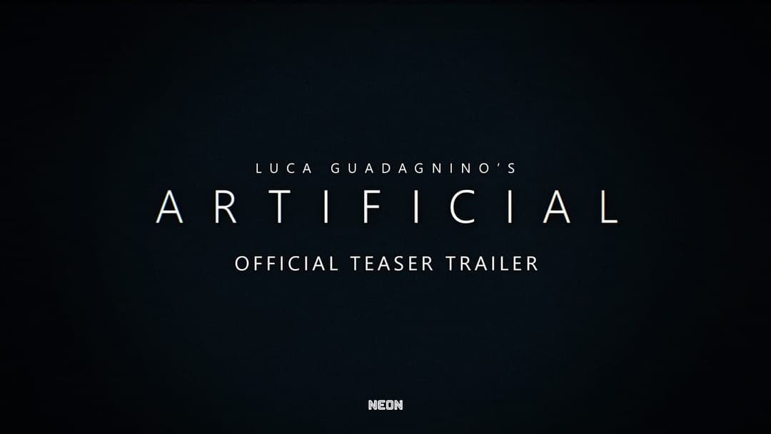 The image is a promotional poster for the movie "Artificial" directed by Luca Guadagnino. The poster is set against a black background, creating a stark contrast that makes the white text stand out. The title of the movie, "Artificial," is prominently displayed in a large, bold font. Below the title, the tagline "Offic