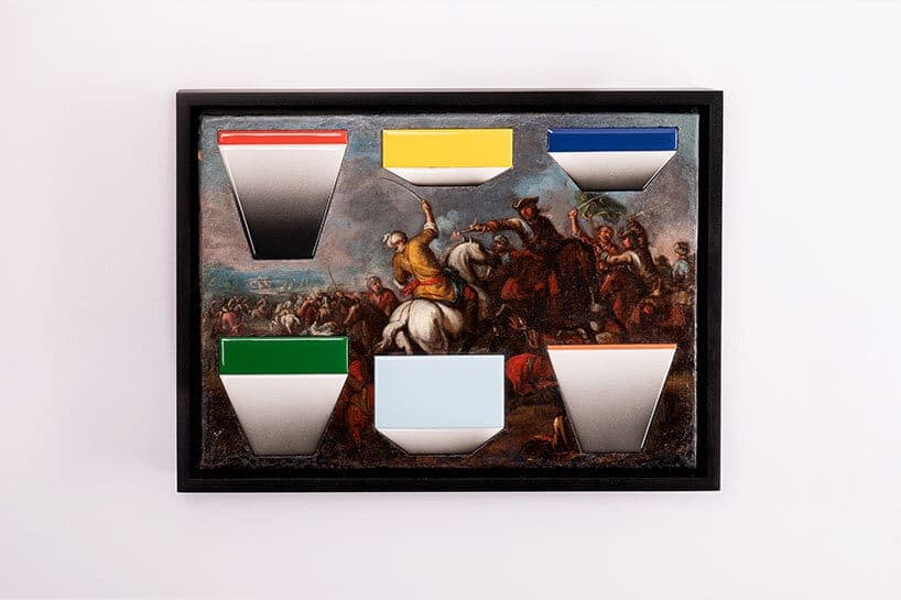 The image shows a framed artwork depicting a historical battle scene. The painting, which appears to be a reproduction of a Dutch Golden Age painting, is set against a white background. The frame is black, providing a stark contrast to the white wall behind it. The painting features a group of people on horseback engag