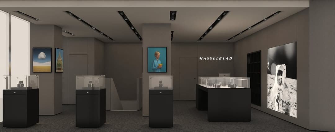 The image presents a modern art gallery with a minimalist aesthetic. The gallery features a neutral color palette of beige and gray, with black accents adding a touch of sophistication. The gallery is illuminated by recessed lighting in the ceiling, casting a soft glow on the artworks and sculptures. The gallery is div