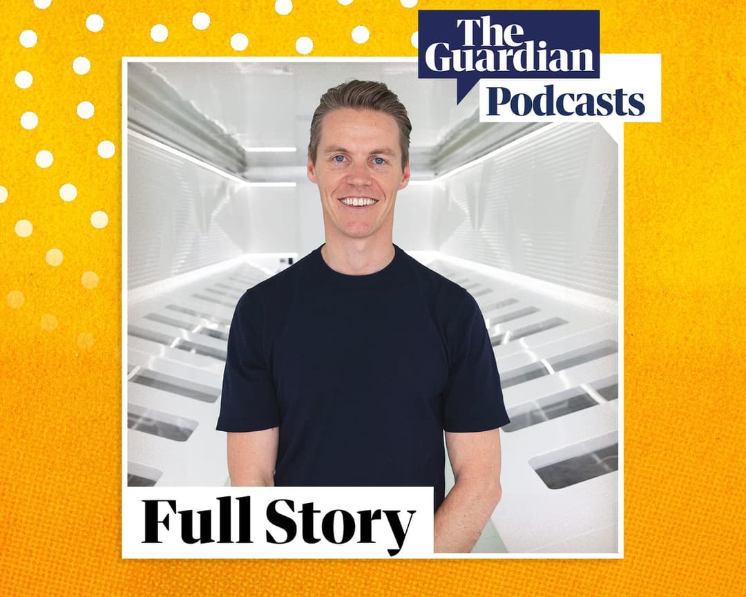 The image shows a man standing in a modern, white corridor with a textured, possibly fabric-like, surface. He is wearing a dark blue t-shirt and has a friendly smile. The corridor features a series of recessed panels or doors along its length. The background is a vibrant yellow with a subtle textured pattern. The image