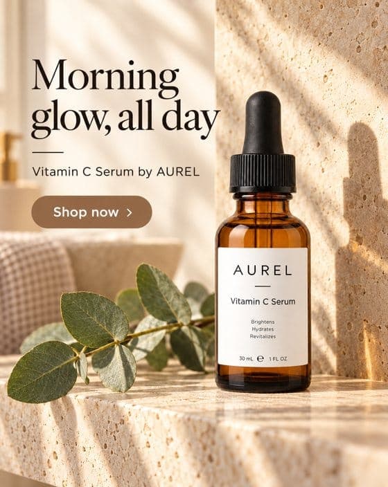 An advertisement with the headline "Morning glow, all day" and the line "Vitamin C Serum by AUREL" above a "Shop now" button. An amber AUREL dropper bottle stands on a sunlit travertine ledge beside a eucalyptus sprig.