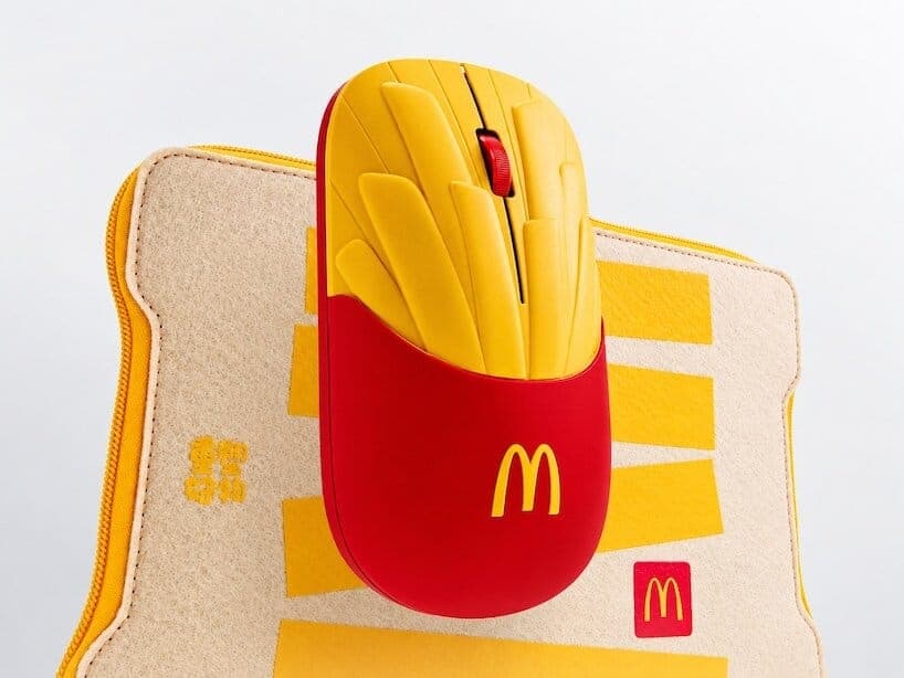 A McDonald's fries-themed wireless mouse rests on top of a cream felt pouch with yellow trim and McDonald's logos. The light grey background is plain.