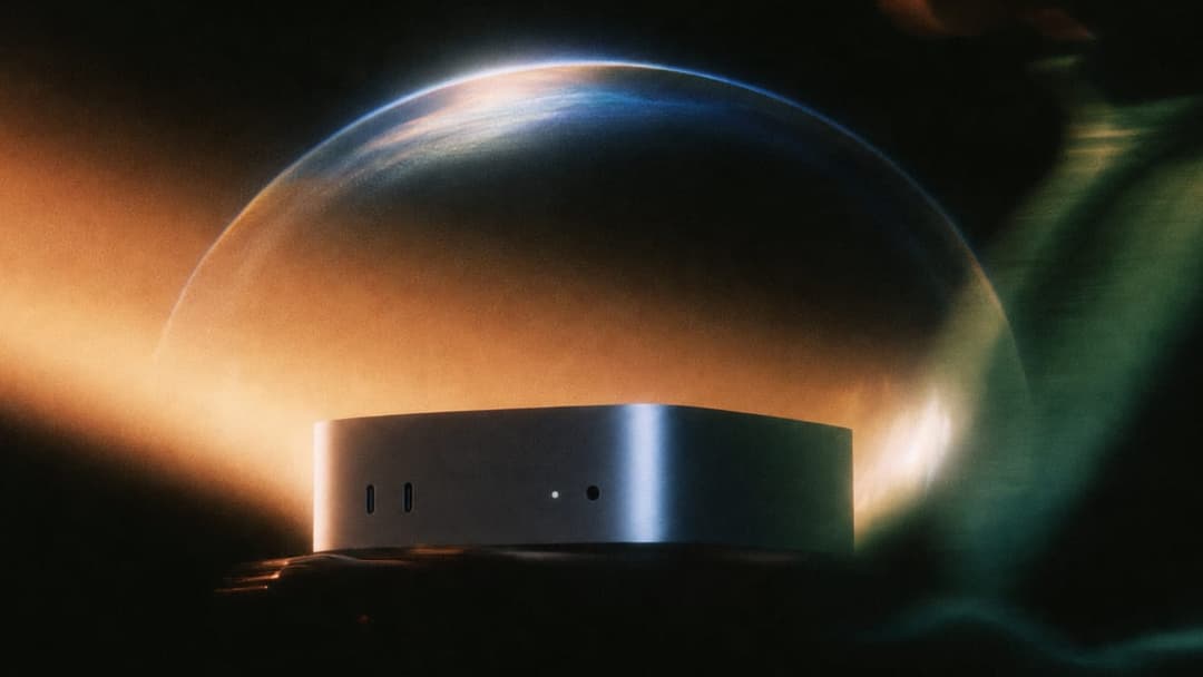 The image presents a sleek, rectangular, metallic device with a silver or gray finish, resting on a dark surface. The device has two small, dark, circular holes on its front. It is positioned in the center of the frame, with a translucent dome, possibly made of glass or plastic, encircling it. The dome has a gradient o