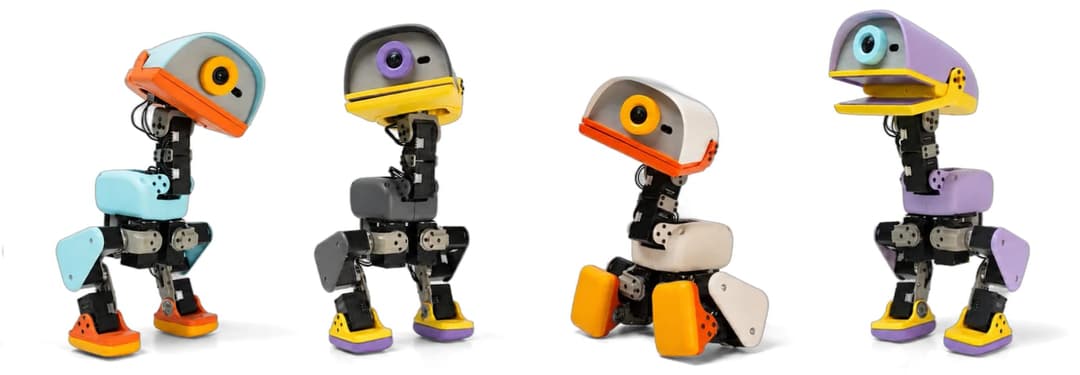 The image presents four distinct robotic figures, each with a unique design and color scheme. The robots are arranged in a row against a black background, creating a striking contrast. The first robot on the left is primarily blue and orange, with a yellow head and orange beak. The second robot is primarily gray and or
