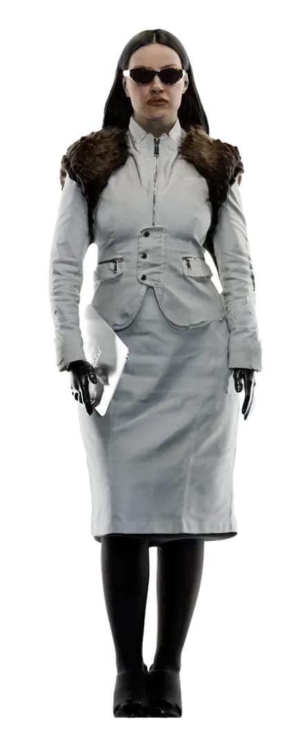 The image shows a woman standing against a stark black background. She is dressed in a white suit, which includes a jacket and a skirt, and a fur-trimmed collar. She is also wearing black tights or stockings and black shoes. She is holding a white folder or portfolio in her left hand. The woman is wearing sunglasses an