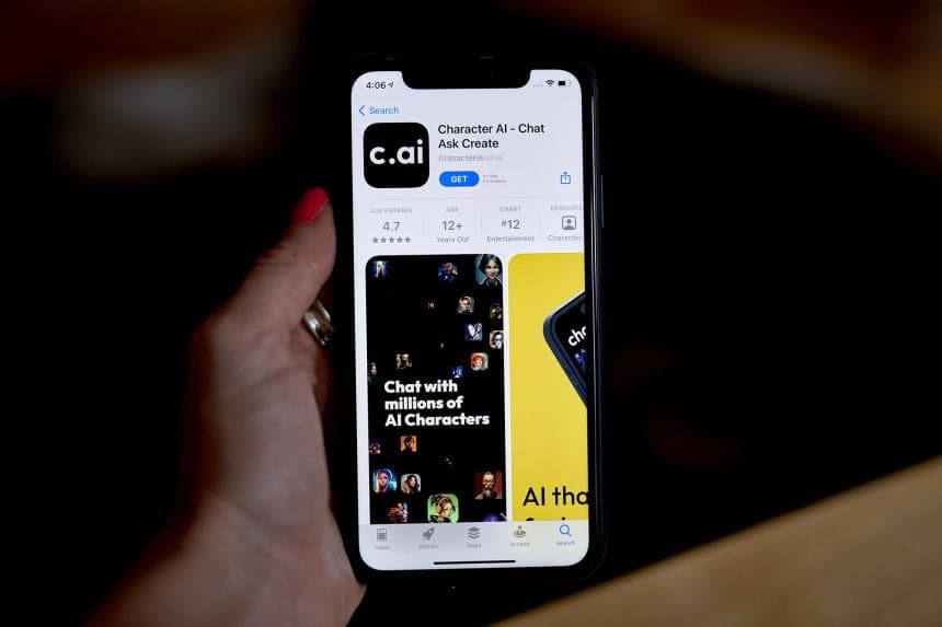 The image shows a person's hand holding a black iPhone, which is displaying the app store page for the "Character AI - Chat Ask Create" app. The app has a rating of 4.7 stars and is available for iOS devices. The app store page shows the app has an average rating of 4.7 stars and has 12+ ratings. The app has a chart, a