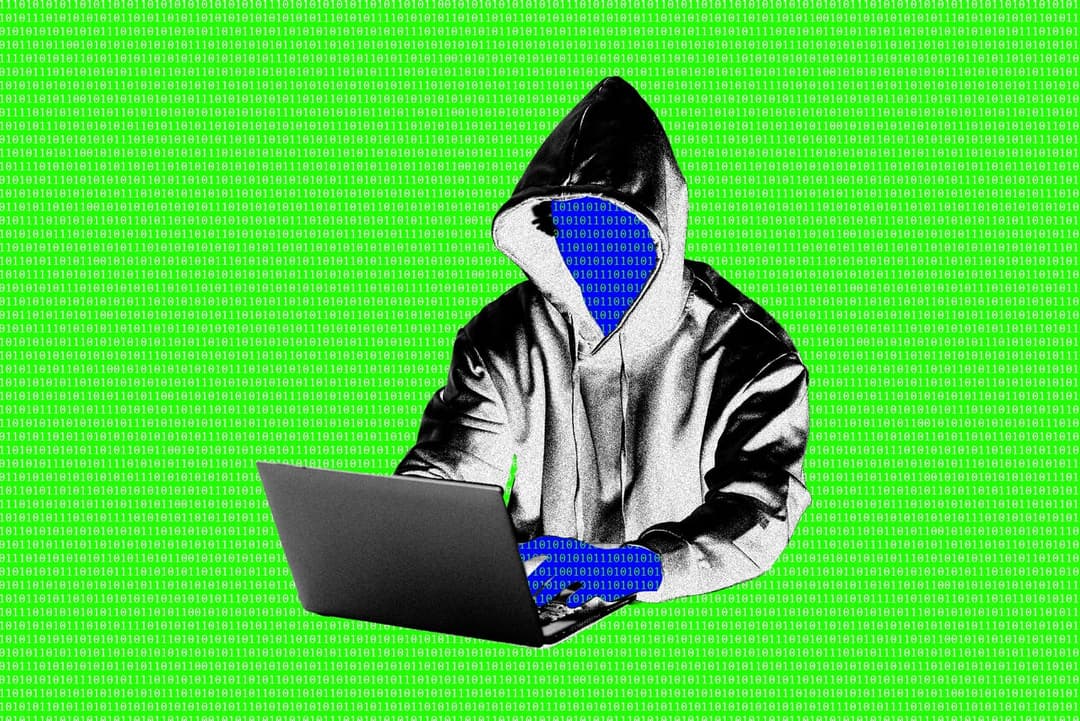 The image depicts a person wearing a black hoodie with a hood, seated and typing on a black laptop. The person's face is obscured by a blue mask, and they are wearing blue gloves. The background is a vibrant green with a repeating pattern of binary code.