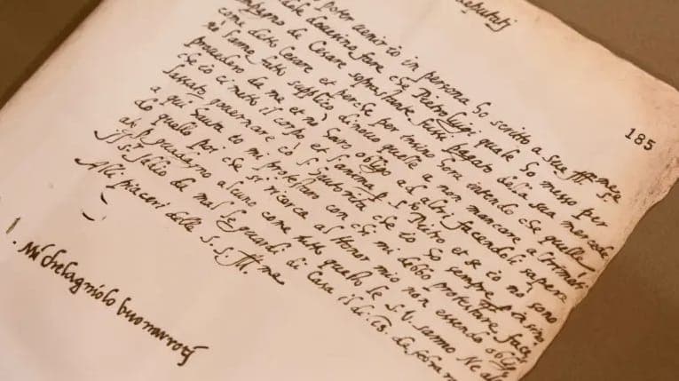 The image shows a close-up view of a page from a book, possibly handwritten in Latin. The page is slightly curled at the edges, and the text is written in a cursive script. The page number 185 is visible in the top right corner. The text is primarily in a single column, with some lines appearing to be split into multip