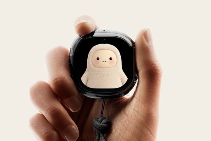 The image shows a hand holding a black smartphone case with a unique design. The case features a small, cartoon-like image of a cream-colored, furry creature with a smiling face. The case has a small, dark blue/black strap attached to the bottom, likely for attaching it to a phone. The hand is positioned in the center