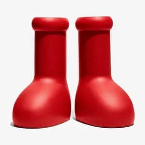 The image presents a pair of red boots, each with a round toe and a slightly curved heel, standing upright on a white background. The boots are positioned side by side, with the toes pointing towards the top left corner and the heels towards the bottom right corner. The boots have a slightly glossy finish, and the red
