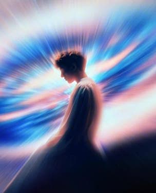 The image depicts a person standing in a vast, swirling blue and pink nebula-like field. The person's face is partially obscured by their hair, and they are wearing a long, flowing garment that appears to be a robe or dress. The image is rendered in a surreal, dreamlike style, with the colors and shapes creating a sens