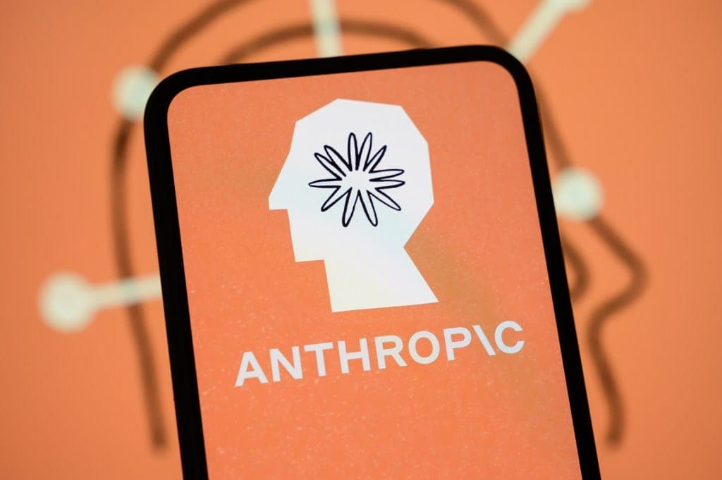 The image shows a close-up view of a smartphone screen displaying the word "ANTHROPIC" in white text. The word is centered on the screen and is positioned below a white, stylized representation of a human head, which is a simplified, geometric shape. The head is outlined in black and features a stylized, flower-like de